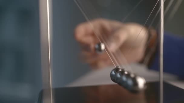 Man Plays Newton Cradle Room Blurry Background Closeup Swinging Steel — Stockvideo
