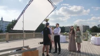 ALMATY, KAZAKHSTAN - JULY 27 2022: Director explains scene to actors at shooting set decorated for wedding ceremony. Movie production organization on July 27 in Almaty