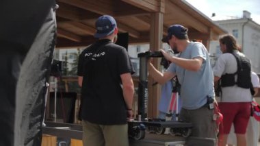 ALMATY, KAZAKHSTAN - JULY 27 2022: Professional shooting team prepares equipment for movie production on summer city street. Film making process on July 27 in Almaty