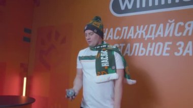 ALMATY, KAZAKHSTAN - 20 HAZİRAN 2023: yaklaşan maçta hokey oyuncularını desteklemek için hokey kıyafeti giyen hayranlar. Erkek modeller, 20 Ocak 'ta Almaty' de pakla birlikte masada oynuyorlar.