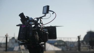 ALMATY, KAZAKHSTAN - JULY 14 2022: Filming crew prepares set and equipment for shooting scene on roof. Professional camcorder with adjusted lens for perfect angle on July 14 in Almaty