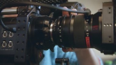 ALMATY, KAZAKHSTAN - JANUARY 27 2023: Cameraman controls professional equipment during filming process. Modern movie camera with big lens shoots film episode on set closeup on January 27 in Almaty
