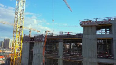 Turnalar, mavi gökyüzünün altında gelecekteki atletizm stadyumu için beton temeller inşa ederler. Modern turnuva arenası hava manzaralı inşaat alanı