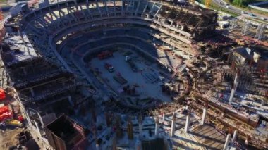 Turnuvalar için vinçler çağdaş stadyumun beton temelini oluşturur. Gölge güneşli bir günde şehir arenasının yarısını kaplıyor.