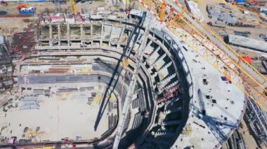 Güneşli bir günde büyük şehir stadyumunun beton temeli üzerinde yüksek vinç yelkeni. Çağdaş atletizm sahasının havadan görünüşü