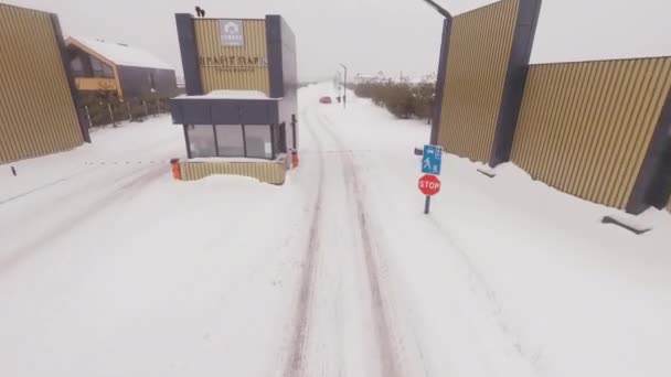 道路上有大雪覆盖的村舍住宅区入口 雪缓缓落下 覆盖着道路和房屋的屋顶 — 图库视频影像