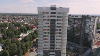 Highrise residential buildings with elegant facades in green city district on summer day aerial view. Urban housing