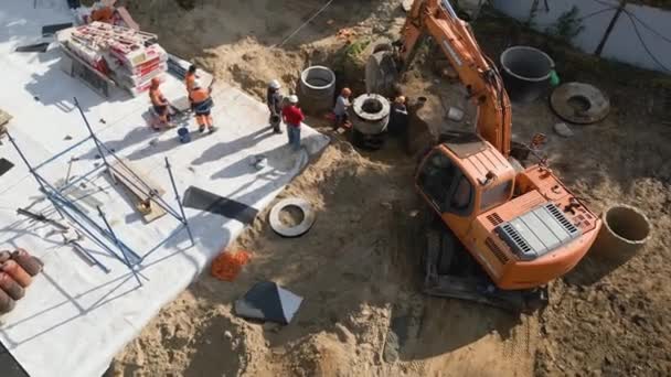 Los Constructores Con Excavadora Entierran Anillos Hormigón Sitio Construcción Vista — Vídeo de stock