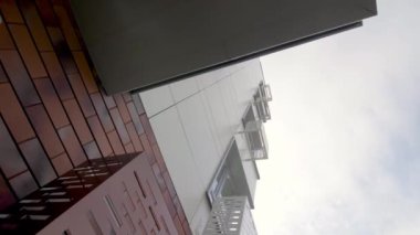 Bulutlu gökyüzü alçak açılı çekimin altında şehir bloğunda kliması olan modern yüksek binalar. Şehir mimarisi