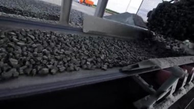 Taş ocağındaki taş ocağının yakınındaki taşıma bandında çakıl cevheri var. Ezme sistemi çıkarılan malzemelerle çalışır