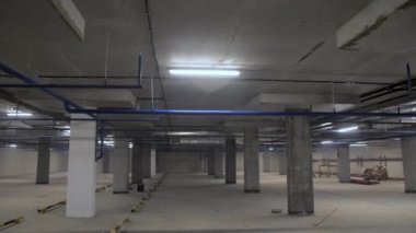 Empty parking site with concrete columns and ceiling under apartment building. Unfinished space for autos storage