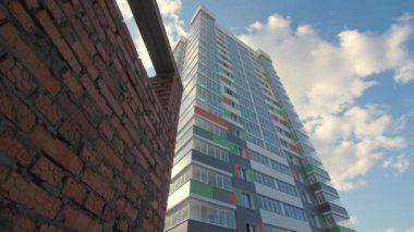 Modern multistory apartment buildings in city district under sky with light clouds. Urban architectural development