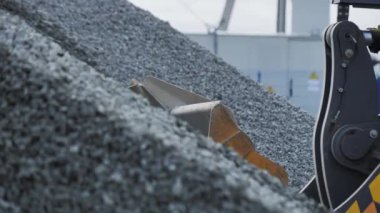 ALMATY, KAZAKHSTAN - EYLÜL 08 2022: Kazıcı maden ocağı yakın görüşünde büyük bir kova ile çakıl kazıyor. Makine, Eylül 08 'de Almaty' de kaya malzemeleriyle çalışır.