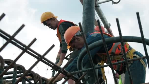Almaty Kazakhstan 2022年9月8日 建設現場の金属フレームを持つ屋根の上に同僚とゴムホースを落下させます 9月8日のアルマトイでの仕事での熟練したビルダー — ストック動画