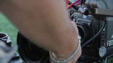 ALMATY, KAZAKHSTAN - 15 Ağustos 2022: Kameraman çekim sahnesi için kusursuz açı için lensi değiştirir. Profesyonel kameraman, 15 Ağustos 'ta Almaty' de yakın çekim sahnesi için lensleri değiştirdi.