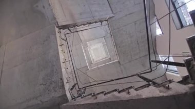 Gri beton merdivenler ve çalışan inşaatçılar gelecekteki binanın alt manzarasında. Kamu merkezinin bakımı