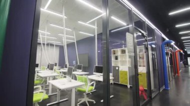 Üniversitede cam duvarlı boş bilişim sınıfında bilgisayarları olan rahat iş yerleri. Öğrenciler için ekipman