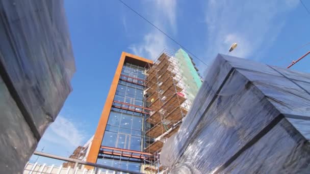 Folia Pokryte Bloki Pobliżu Niekompletnego Budynku Wielopiętrowego Placu Budowy Zbliżenie — Wideo stockowe