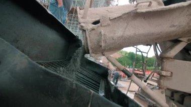 İnşaat inşaatı için gerekli malzemeyi miksaj makinesine döküyorum. Profesyonel inşaatçılar inşaat alanındaki süreci denetler