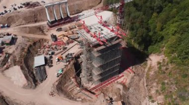 İnşaat alanında vinç makineleri ve gerekli malzemelerle donatılmış yenilikçi yol köprüsü destek inşaatı. Otoyolun inşaatı