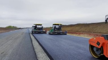 ALMATY, KAZAKHSTAN - 17 Şubat 2023: asfalt silindirler ve kaldırım makineleri otoban hava görüşünde. 17 Şubat 'ta Almaty' de modern teknolojiyle eski yolun geliştirilmesi