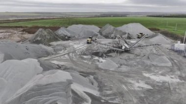 Taşıyıcı sistem ve kazan kepçesi geniş açık çakıl ocağı hava manzarasında. Kaya cevheri madde çıkarma endüstrisi