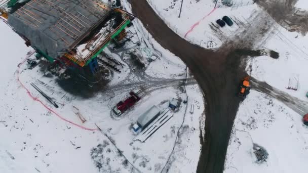 将来の輸送橋は 雪の谷の空中ビューの建設現場で足場でサポートしています 田舎の高速道路開発 — ストック動画