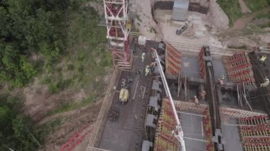 İnşaatçılar, gelecekteki ulaşım köprüsünün yeşil boş hava manzaralı bölümünde çalışıyorlar. İnşaat teknolojisiyle altyapı geliştirme