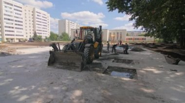 ALMATY, KAZAKHSTAN - Haziran 06 2022: inşaat sahasına beton dökmek için kepçe kazıyor. İnşaatçılar, kazıcıların beton taban için taş ve toprak artıklarını kaldırmasına yardım ediyor.
