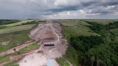 Zemin yolunun pürüzsüz yüzeyi güneşli bir günde yeşil alanda asfalt döşemeye hazır. Kırsal yapı geliştirme