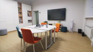 Oyun odasında oyuncaklarla ve renkli kalemlerle dolu bir masa. Çağdaş ofis merkezinde çocuklar için mobilyalarla dinlenme alanı