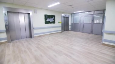 Ofis binasının büyük lobisindeki duvarda Rusya haritası asılı. Asansörlü ve ışıklı ticari şirketler koridoru.