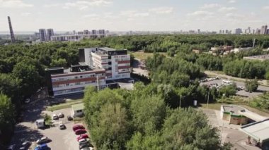 ALMATY, KAZAKHSTAN - Eylül 07 2022: Yaz günü kuş bakışı yeşil ağaçların arasında park yeri olan üretim şirketi merkezi. Ticari mimari nesne