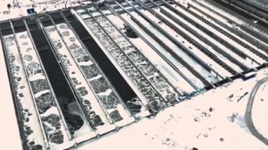 Havalandırmalı ve donmuş suyla dolu havzalar kış günü hava manzaralı modern arıtma tesisinde. Kanalizasyon materyalleri filtreleniyor ve işleniyor