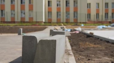 Güneşli bir günde yeniden inşa edilen parka giden büyük beton bloklar. Kentsel alan bakımı için inşaat malzemeleri