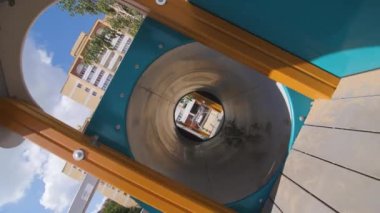 Çocukların geçtiği tünel, yerleşim yerlerinin yakınındaki kum parkında labirent görevi görüyor. Yaz kenti parkında çocuklar için eğlence kameraları dönüyor