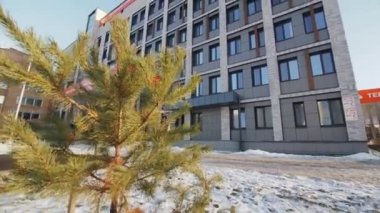 ALMATY, KAZAKHSTAN - 09 Şubat 2023: Gri cepheli ve kırmızı logolu ticari bina karlı caddenin girişinin üzerinde. Winter City bölgesindeki şık bir ofis.