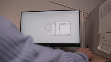 ALMATY, KAZAKHSTAN - 17 APRIL 2023: Mühendis bilgisayarı kapatma programında ayrıntılı sanal model açıyor. Tasarımcı ofiste paketin 3 boyutlu görselleştirmesini oluşturdu