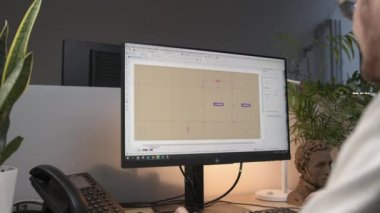 ALMATY, KAZAKHSTAN - 17 APRIL 2023: Mühendis, bilgisayar kapatma programında karton paket planlarını kontrol ediyor. Çalışan yazılım ile dijital plan oluşturur