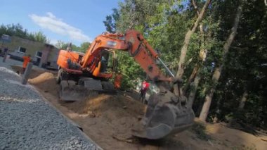 ALMATY, KAZAKHSTAN - 10 Mayıs 2023: Modern buldozer kovası konut inşa etmek için yüzeye kum döker. İnşaat malzemesi ve iş akışı konsepti. Konaklama inşaatı