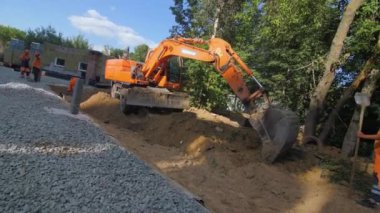 ALMATY, KAZAKHSTAN - 10 Mayıs 2023: Modern buldozer inşaat malzemelerini taşımak için kovaya kum topluyor. İnşaatçıların konaklama inşaatı ve izleme çalışmaları kavramı