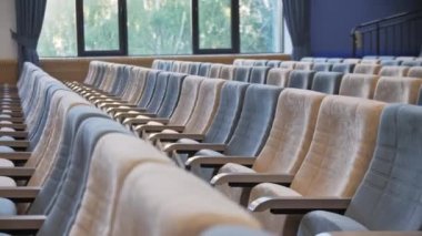 Boş konser salonlarında kadife döşemeli seyirciler için koltuklar. Konferans salonunun geniş penceresine karşı sandalyeler