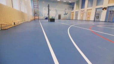 Çağdaş okul spor salonunda voleybol ağı ve merdiven, şık bir süs eşyasıyla. Spor salonunda top oynanan takım oyunları için büyük bir spor sahası