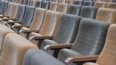 Boş konser salonlarında ahşap kollukları olan yumuşak koltuklar. Konferans salonundaki konuklar için rahat seyirci yerleri