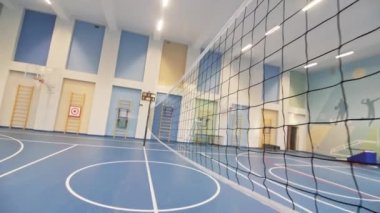 Spor salonunda voleybol sahasının ortasında tekstil ağı. Çocuk atletizm merkezinde top oynanan spor oyunları için ekipman
