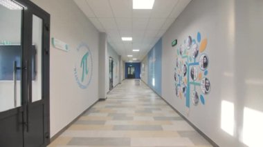 Matematik problemleri olan büyük bir saat ve aydınlatılmış okul koridorunda farklı matematiksel semboller. Eğitim kurumunun iç tasarımı