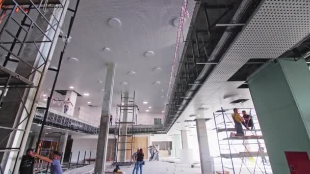 Almaty Kazakhstan May 2023年5月16日 請負業者チームは 将来のビジネスセンターのスローモーションの中で働いています 改装された建物内の列と足場と広々とした廊下 — ストック動画