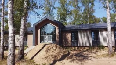 Yarım ofis yakınında kum yığını ve huş ağacı orman hava manzaralı cam giriş. Ahşap inşaat alanındaki spor merkezi.