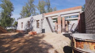 İnşaat alanında malzeme ve enkaz ile tamamlanmamış beton bina. Ormancılık alanında modern mimari proje geliştirme