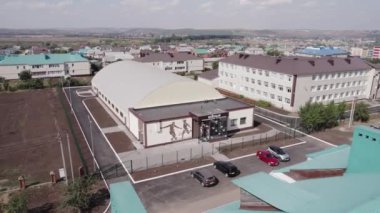 ALMATY, KAZAKHSTAN - 09 Mayıs 2023: Çağdaş futbol arena binası yarı daire çatısı ve şehrin hava manzarası ön cephesinde resim. Top oyunları için kapalı saha